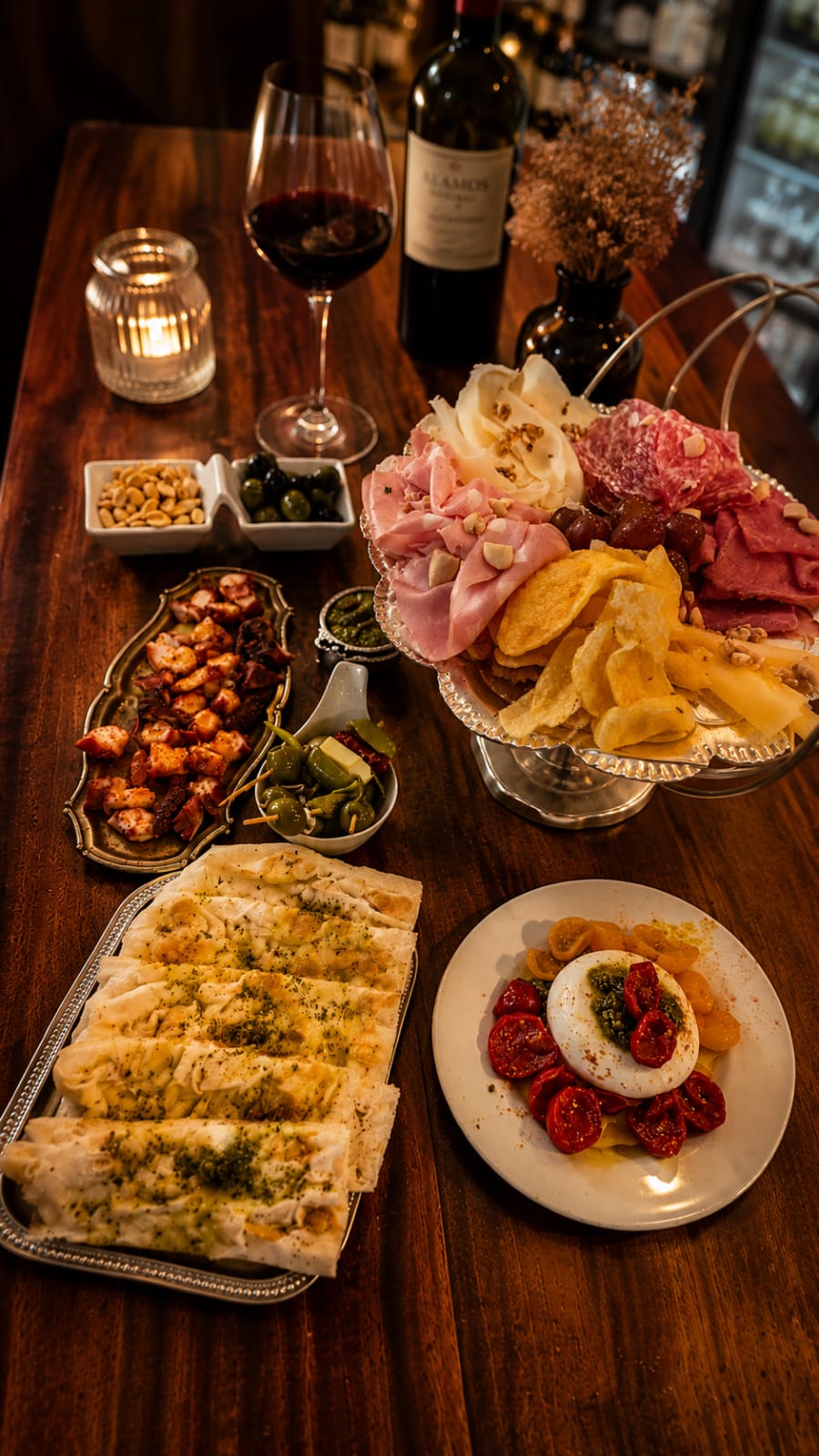 Mesa servida con vino, tablas y velas